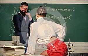 Impudent student. Flirting colleague. Girl sexy buttocks sit table. Everyone dreaming about such teacher. Lustful tutor photo