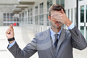 Impulsive businessman playing darts with his eyes closed