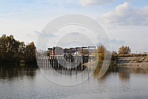 Inactive abandoned dam in the Upper Tula Novosibirsk region in autumn beautiful landscape with engineering design on the ri