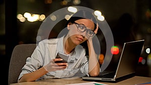 Inattentive young woman chatting smartphone, avoiding work, job indifference