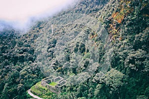 Inca Trail hiking path to an ancient ruin crossing the wild jungle.