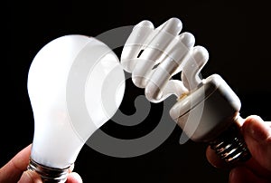 Incandescent and cfl lightbulb on black