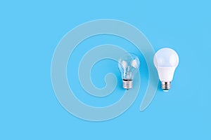 incandescent lamp and led lamps against on isolated blue background. Energy efficiency concept