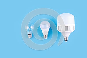 incandescent lamp and led lamps against on isolated blue background. Energy efficiency concept