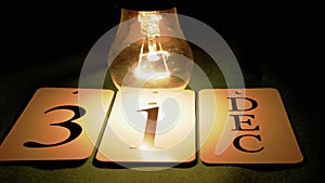 Incandescent Light Bulb Swaying, Flashing over a Calendar with Date December 31