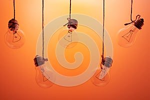 Incandescent light bulbs hanging on a orange background