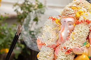 Incense or agarbatti sticks in front of lord vinayaka or Ganesha while worshiping during ganesha chaturthi or vinayaka