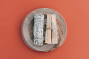 Incense bundle for meditation and room fumigation. White sage and palo santo sticks on wooden stand