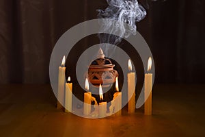 Incense burning in an incense burner with candles on the table for praying Buddha or Hindu gods to show respect.