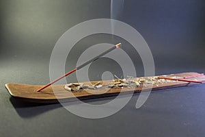 Incense with smoke in a small wooden table. Black background isolated