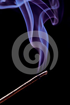 Incense stick smoking, vertical color photo