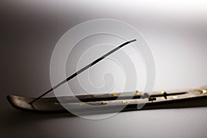 Incense stick on a wooden support on a white background