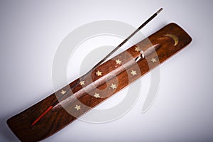 Incense stick on a wooden support on a white background