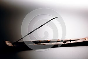 Incense stick on a wooden support on a white background