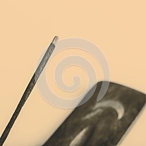 Incense stick on a wooden support on a white background