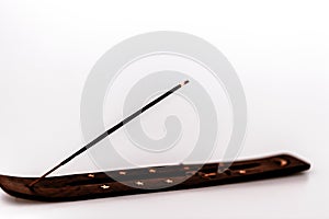 Incense stick on a wooden support on a white background