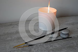 Incense sticks and burning candles on the table.