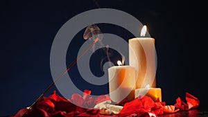 Incense sticks and candles are burning and smoke on dark background,Smoke from incense and candle light