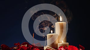 Incense sticks and candles are burning and smoke on dark background,Smoke from incense and candle light