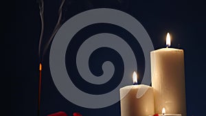 Incense sticks and candles are burning and smoke on dark background,Smoke from incense and candle light