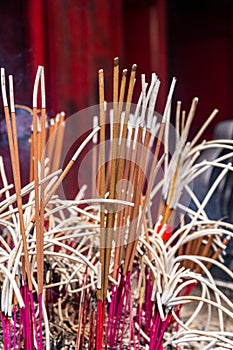 Incense sticks close-up in the Temple of Literature Quoc Tu Giam, Hanoi, Vietnam. Vertical view