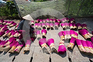 Incense sticks drying outdoor with Vietnamese woman wearing conical hat in north of Vietnam