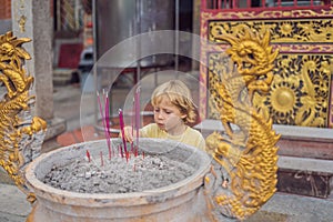 Incense sticks on joss stick pot are burning and smoke use for p