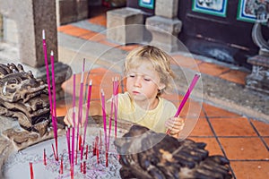 Incense sticks on joss stick pot are burning and smoke use for pay respect to the Buddha, Incense sticks in boy hand and