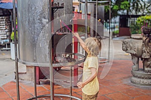 Incense sticks on joss stick pot are burning and smoke use for pay respect to the Buddha, Incense sticks in boy hand and