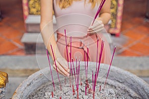 Incense sticks on joss stick pot are burning and smoke use for pay respect to the Buddha, Incense sticks in woman hand