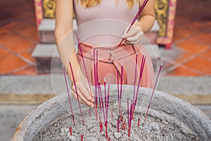 Incense sticks on joss stick pot are burning and smoke use for pay respect to the Buddha, Incense sticks in woman hand