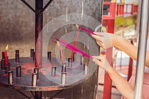 Incense sticks on joss stick pot are burning and smoke use for pay respect to the Buddha, Incense sticks in woman hand and smoke u