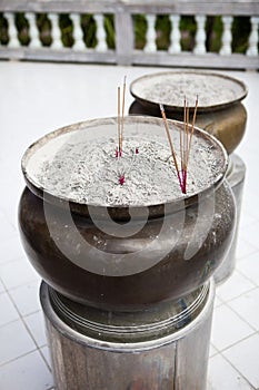 Incense sticks on joss stick pot are burning and smoke use for praying Buddha or Hindu gods to show respect