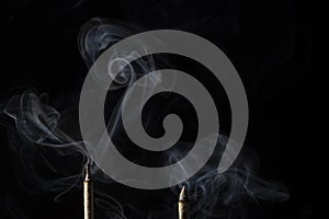 Incense Sticks, smoke blown by wind making abstract and surreal shapes and patterns in smoke