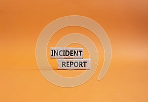 Incident Report symbol. Concept word Incident Report on wooden blocks. Beautiful orange background. Business and Incident Report