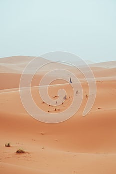 Incidental local berber man wandering through Sahara Desert Merzouga, Morocco photo