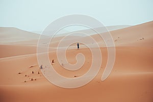 Incidental local berber man wandering through Sahara Desert Merzouga, Morocco photo