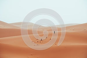 Incidental local berber man wandering through Sahara Desert Merzouga, Morocco photo