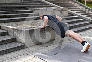 Incline push-up doing by a young athletic man. Push-up modification for beginners