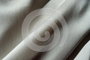 Inclined soft folds on grey chiffon fabric