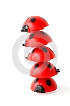 Inclined tower made of five red small ladybugs