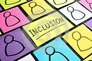 Inclusion sign and sheets with drawn of figures. photo