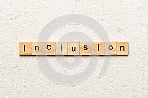 Inclusion word written on wood block. Inclusion text on cement table for your desing, concept