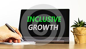 Inclusive growth symbol. Concept words Inclusive growth on beautiful black tablet. Beautiful white background. Businessman hand.