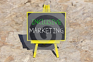 Inclusive marketing symbol. Concept words Inclusive marketing on beautiful black blackboard. Beautiful stone beach background.