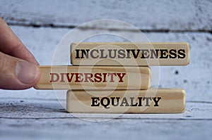 Inclusiveness, diversity and equality text on wooden blocks with wooden cover background. Business culture team concept photo