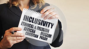 Inclusivity Asian Caucasian African Muslim Christian words on a card Businesswoman holding big card with a message text written on