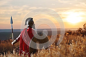 Incognito warrior in iron helmet and red cloak. photo