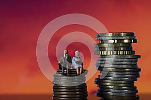 Income Tax Campaign Spain. Old Couple sitting on coin stack.. Declaracion de la Renta. Macro photo