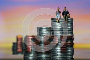 Income Tax Campaign Spain. Young Couple sitting on coin stack. Declaracion de la Renta. Macro photo